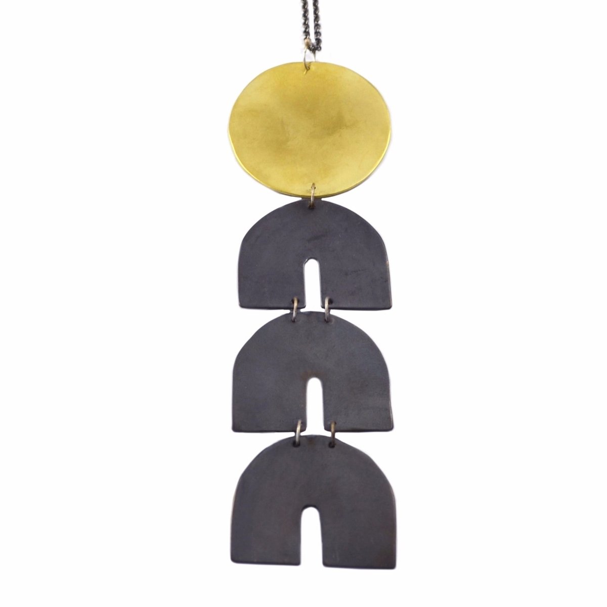 A four tiered pendant necklace constructed of three oxidized brass arches and one gold tone brass circle. The Telesto necklace is designed and handcrafted by Natalie Joy in Portland, OR.