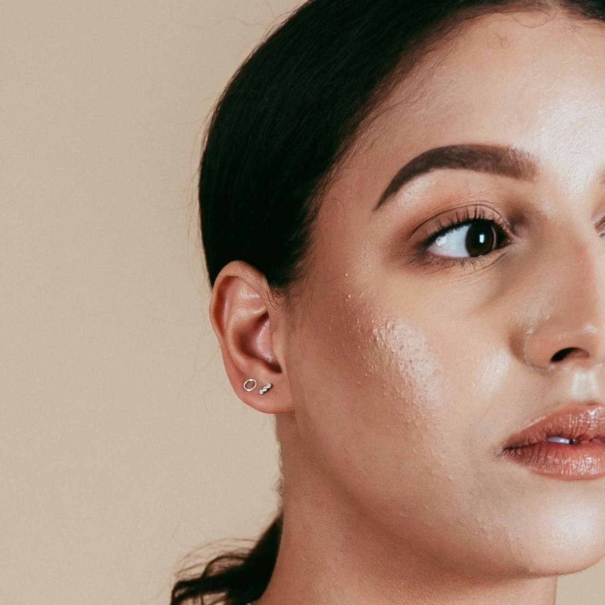 Model wears sterling silver three dot stud earrings. The Three Dot Studs are designed and handcrafted by Deivi Arts Collective in Vancouver, Canada.