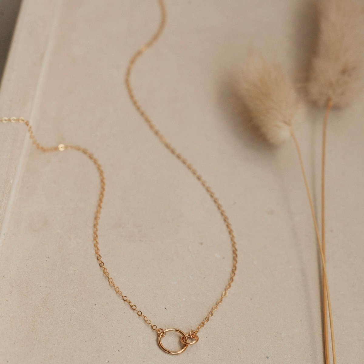 A dainty gold tone chain necklace connected with two tiny links. The Tiny Links Necklace is handcrafted by Hello Adorn in Eau Claire, WI.