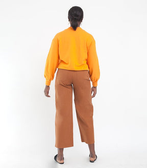 Model shows back side of cropped wide leg jeans in Tan. The Toni Jeans in Tan are designed by Loup and made in New York City, USA.