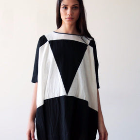 Black and cream tunic style dress with a color-blocked triangle design. Designed and sewn by UZI in Brooklyn, New York.