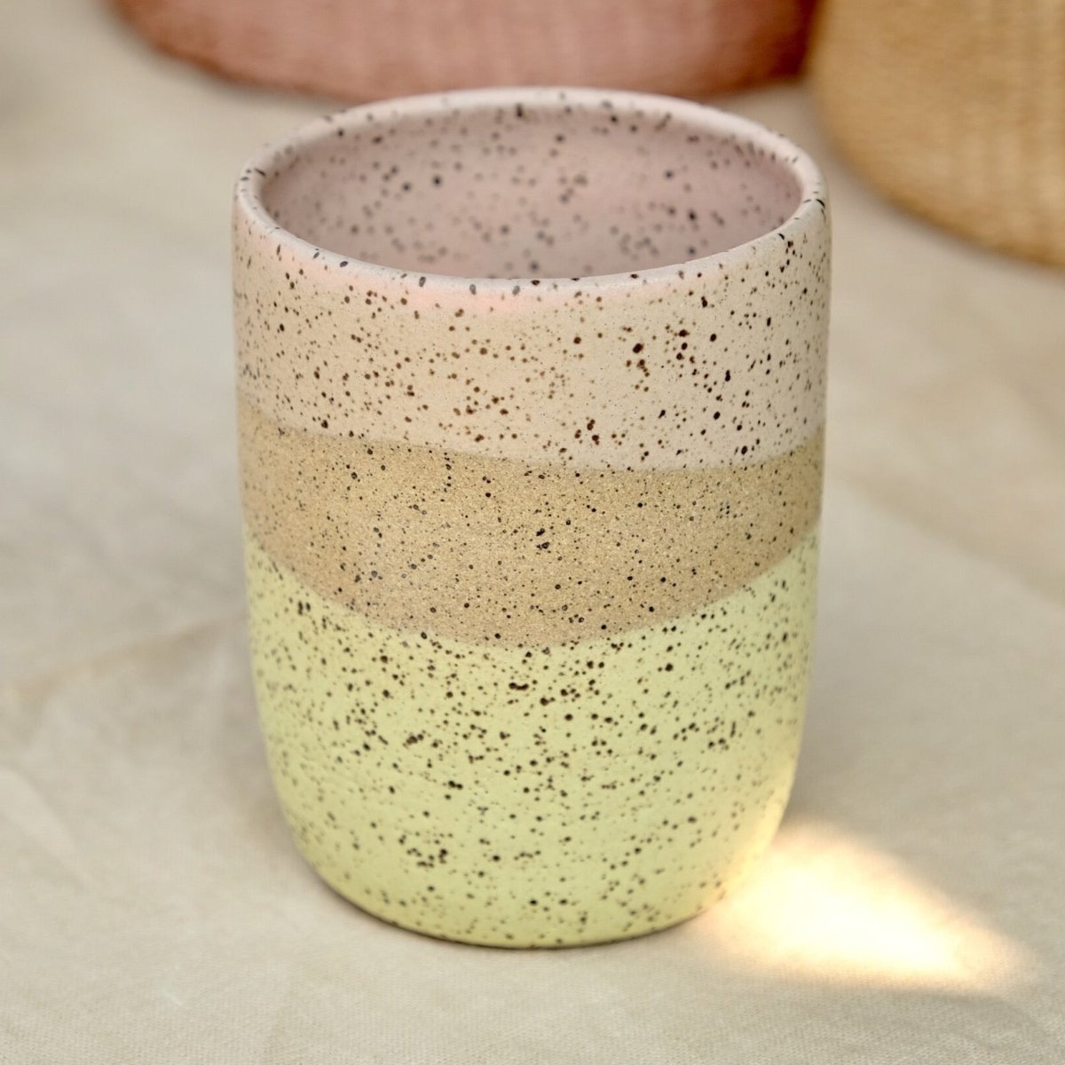 10oz tumbler glazed with matte yellow and pink colors over a speckled clay body. Designed and handmade by Sunflower Studio in Portland, Oregon.