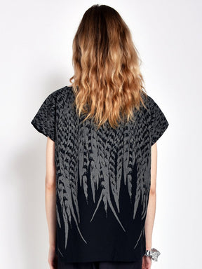 Model shows back of short sleeve black tunic with grey feather design. Designed and sewn by Uzi in Brooklyn, New York.