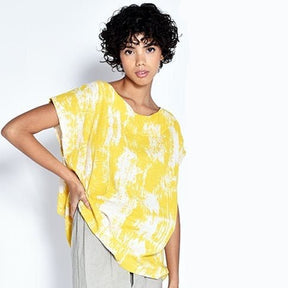 A model wears a short sleeve tunic with a bright yellow painted design. The Tun in Yellow Bark is designed by UZI NYC and sewn in Brooklyn, New York. 