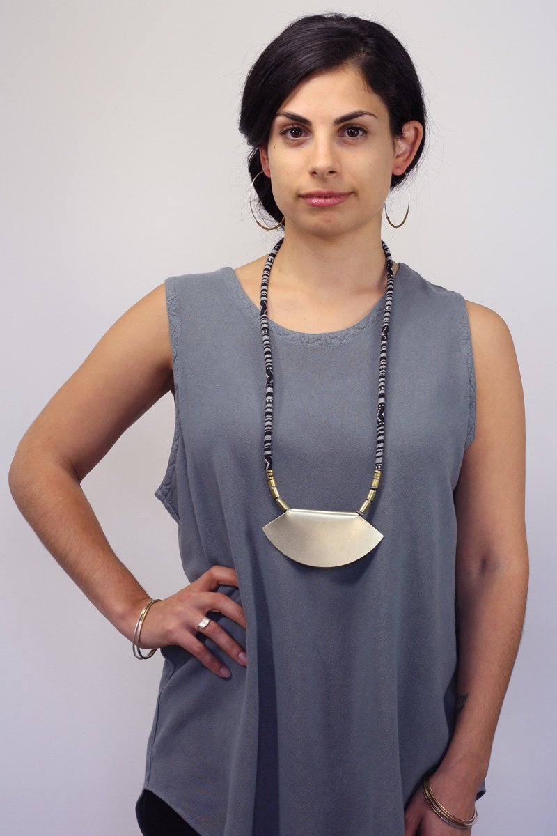 Betsy & iya sterling silver and brass Uusi hoop earrings, styled on a model with a large, retired, betsy & iya statement necklace.
