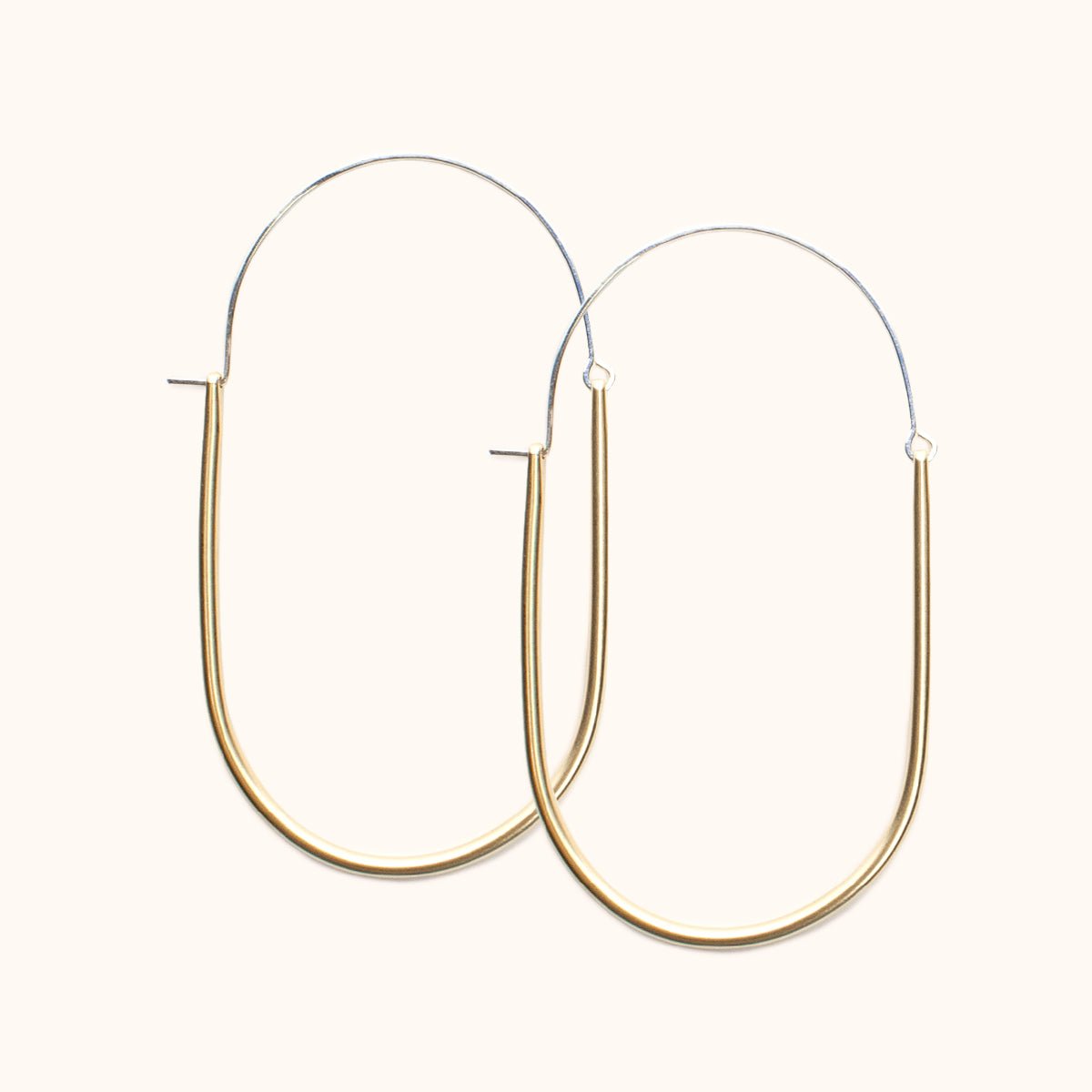  A large sterling silver and brass U-shaped earring with an arched ear wire that meets the top of the U. Designed and handcrafted in Portland, Oregon.