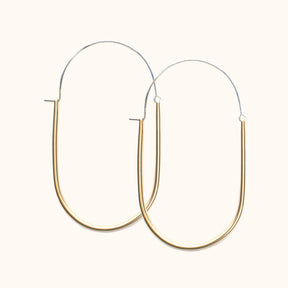  A large sterling silver and brass U-shaped earring with an arched ear wire that meets the top of the U. Designed and handcrafted in Portland, Oregon.