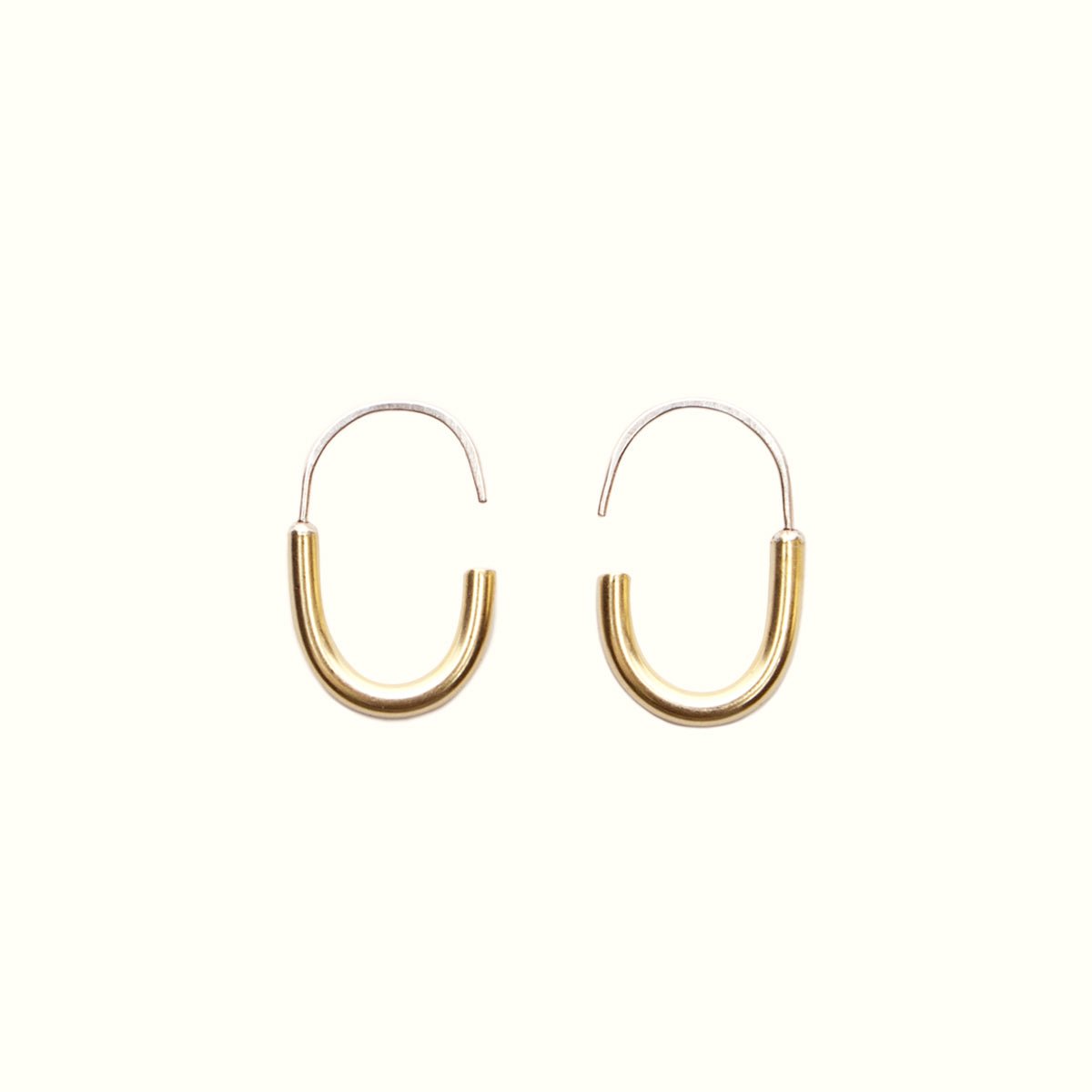 A mini brass hoop U-shaped earring with an arched sterling silver ear wire with a slight opening. Designed and handcrafted in Portland, Oregon.