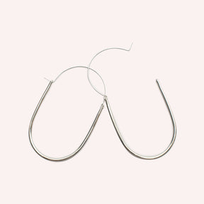  A large sterling silver U-shaped earring with an arched ear wire that meets the top of the U. One ear wire is unhooked and open. Designed and handcrafted in Portland, Oregon.