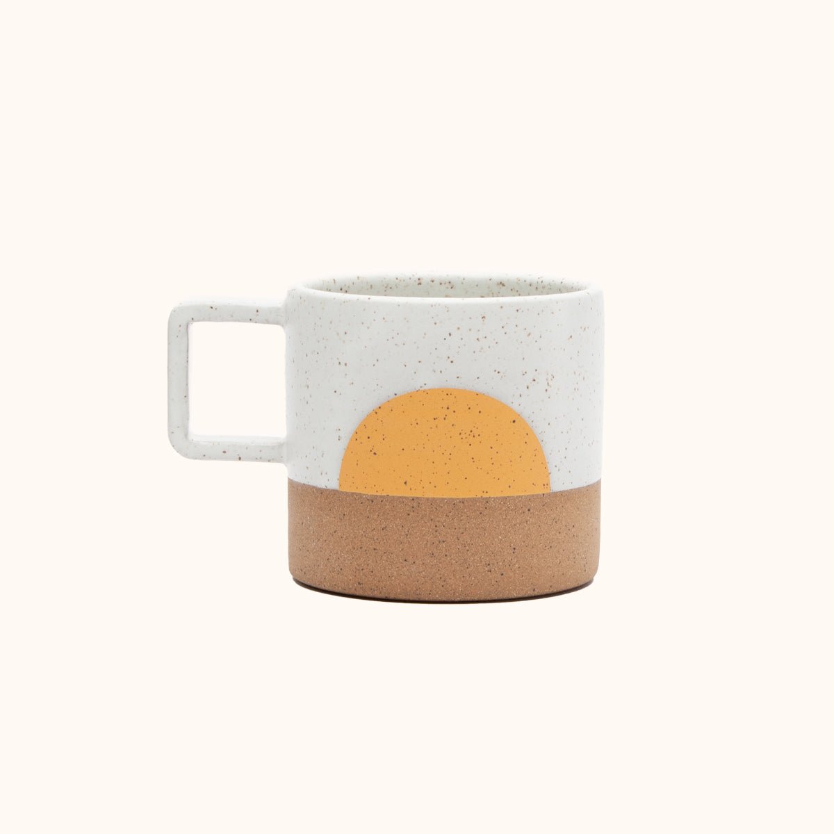 A mug with a white speckled and natural clay finish with a half moon design in a warm yellow. The Speckled Sunrise Mug is designed and handmade by Wolf Ceramics in Hood River, Oregon.