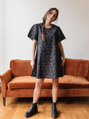 Mini dress with lightly ruffled shoulders in a navy jungle print. Designed by Mata Traders and made in India.