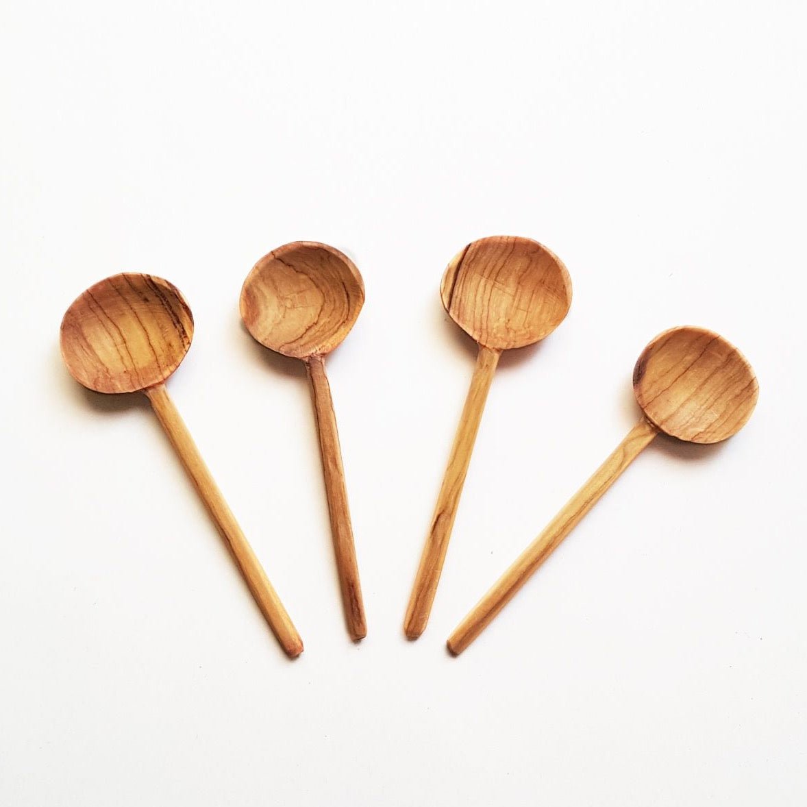 Petite spoons made of olive wood. The Olive Wood Coffee Spoon is designed by Creative Women and hand carved in Kenya.