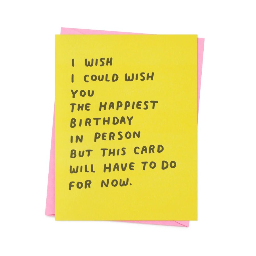 Yellow greeting card with black text that reads "I WISH I COULD WISH YOU THE HAPPIEST BIRTHDAY IN PERSON BUT THIS CARD WILL HAVE TO DO FOR NOW." The Happiest Birthday card by Ashkahn is designed in Los Angeles and printed in Portland, Oregon.