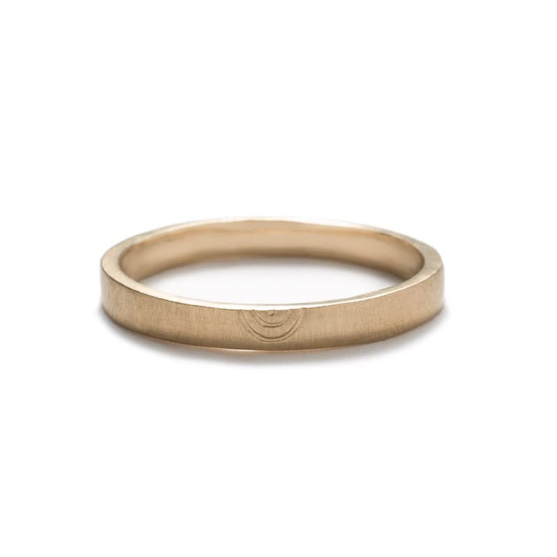 Narrow, flat, 14k yellow gold band with a matte finish and a minimalistic, hand-carved, semi-circle design that is reminiscent of a rainbow. Hand-crafted in Portland, Oregon.