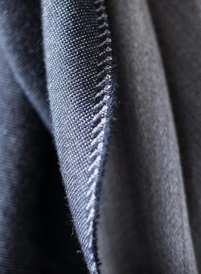 Closeup of the The Eden Reversible Scarf in Black from Bloom & Give. It is 100% Merino Wool done by hand on a loom.