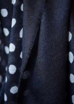 Closeup of the Maya Dot Scarf in Black by Bloom & Give. The scarf is 92% Merino Wool and 8% Silk.