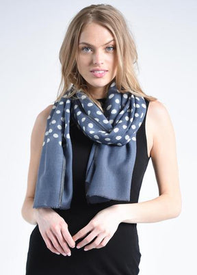 Blonde woman wears a blue scarf with white dots and a black tank top. The Maya Dot Scarf in Blue is from Bloom & Give.