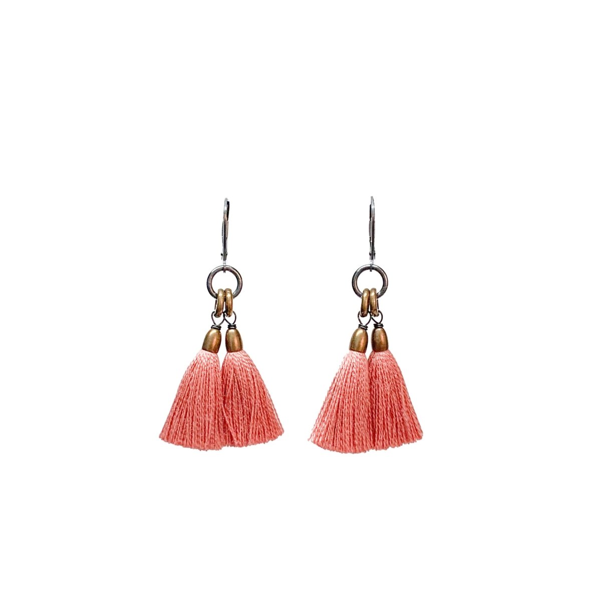 A pair of dangling earrings with blush pink tassels and brass rings topped with a silver leverback. The Fan Earrings in Shell are from Portland designer Emily Bixler of BOET.