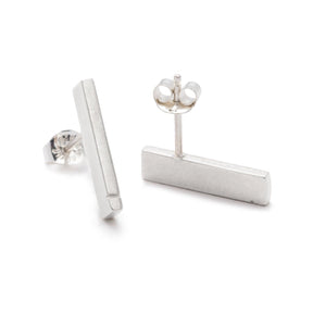 Slim, rectangular sterling silver bars with a notch detail at one end, soldered to sterling silver earring posts, and finished with sterling silver butterfly earring backings. Hand-crafted in Portland, Oregon. 