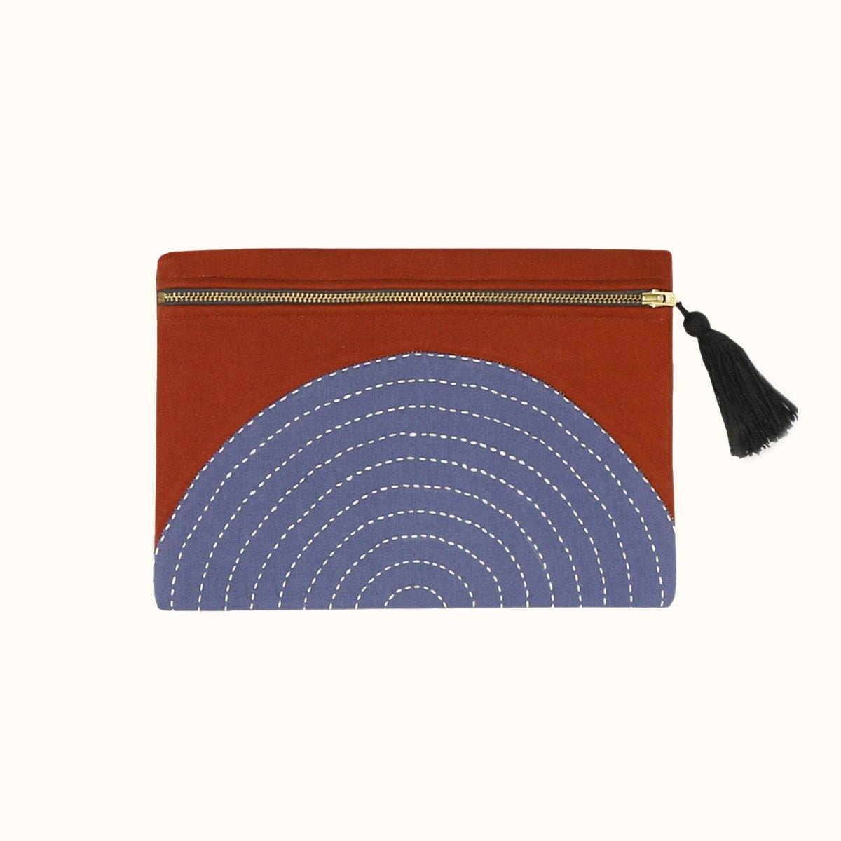 Rust colored square pouch with a slate grey cross-stitch concentric pattern. Includes a zipper with a black tassel. Designed by Anchal in Louisville, Kentucky and handmade in Ajmer, India.
