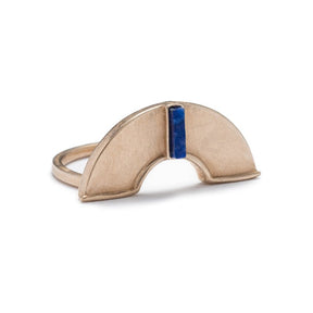 A unique, cast-bronze, half-circle shield, set atop a bronze band, and inlaid with a rectangular, blue, lapis lazuli stone. Hand-crafted in Portland, Oregon.