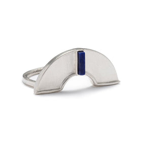 A unique, sterling silver, half-circle shield, set atop a sterling silver band, and inlaid with a rectangular, blue, lapis lazuli stone. Hand-crafted in Portland, Oregon.