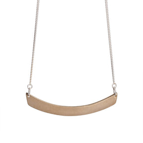 Minimal, curved, cast-bronze pendant, affixed to a sterling silver chain, with a hand-formed sterling silver clasp and closure. Hand-crafted in Portland, Oregon. 