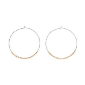Lightweight, thin, sterling silver statement hoop earrings, accented with small, brass, African trade beads. Hand-formed in Portland, Oregon. 