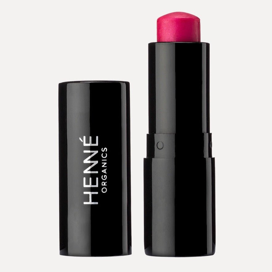 A tube of bright pink lip tint. The Luxury Lip Tint in Azelea is designed by Henné Organics and made in the USA.
