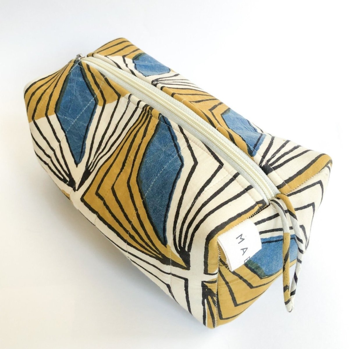 A yellow, cream and blue patterned cosmetic bag. The Hattie Cosmetic Bag from Maelu is designed in Portland, Oregon and printed and made in India.