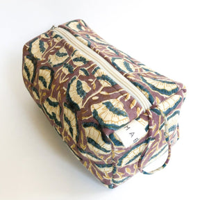 A brown, cream and dark blue floral patterned cosmetic bag. The Lena Cosmetic Bag from Maelu is designed in Portland, Oregon and printed and made in India.