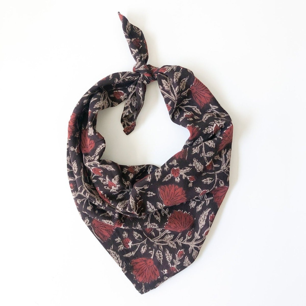 A floral printed bandana, folded over and tied in a knot. Block printed by hand, the Rosa Bandana from Maelu is designed in Portland, Oregon and handmade in India.