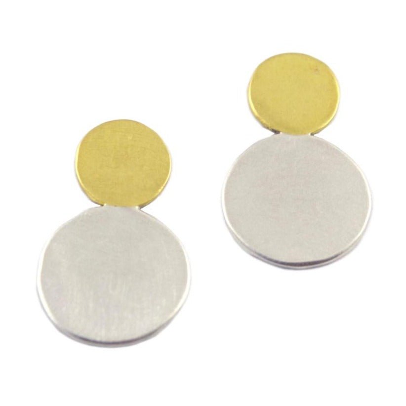 A pair of brass and silver earrings against a white background. The earrings are comprised of two circles– a smaller brass circle sits atop a medium silver circle. The Moonlet Post earrings are made by designer Natalie Joy in Portland, Oregon.