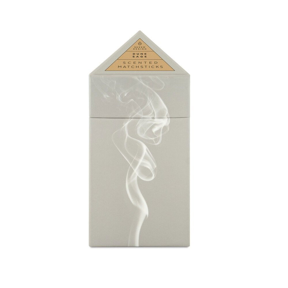 Triangular box holding matches against a white background. The box is grey with a picture of white smoke. The Prism Scented matches are from designer Skeem and made in the USA.