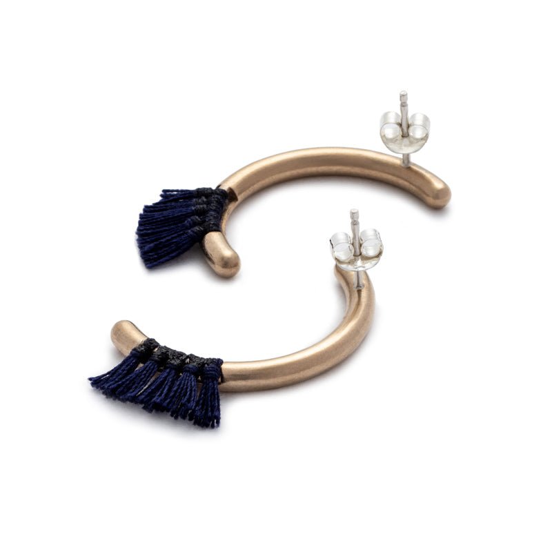 Modern, parentheses-shaped bronze studs with navy cotton fringe, sterling silver earring posts, and sterling silver ear nuts. Hand-crafted in Portland, Oregon.