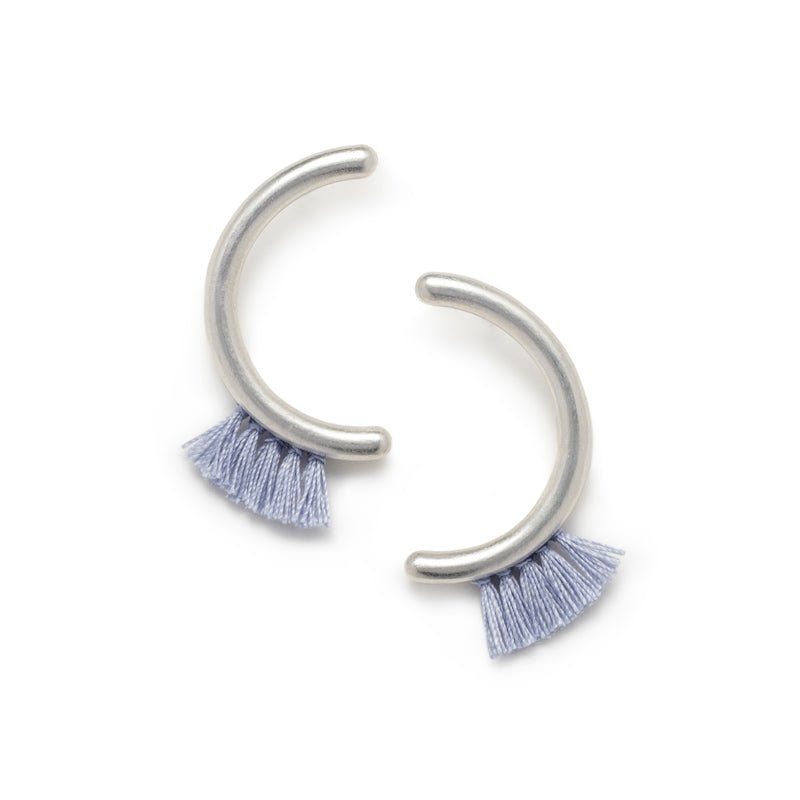 Modern, parentheses-shaped silver studs with light blue cotton fringe. Hand-crafted in Portland, Oregon.