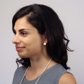 14k gold-plated Rustu stud earrings (now a retired style), pictured on the profile of a model with dark hair and a gray tank top.