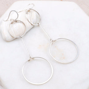 Two hand forged and hammered silver circles come together with a gold bar in between. The Double Circle Drop Earrings in Silver are designed and handmade by Amy Olson in Portland, Oregon.