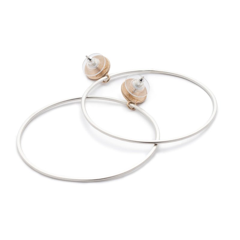 Sleek bronze studs featuring a bezel set, fair trade, and ethically sourced lapis lazuli, sterling silver posts, sterling silver and plastic comfort-clutch backings, and large silver hoops dangling below. Hand-crafted in Portland, Oregon. 
